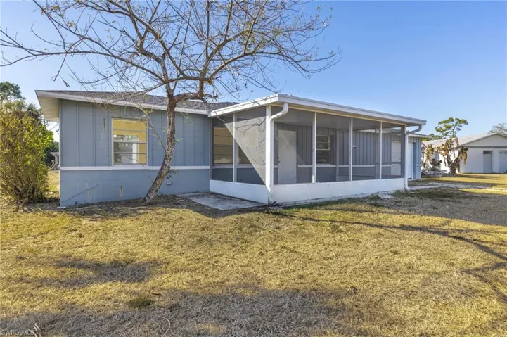 Back of house featuring a yard and a sunroom