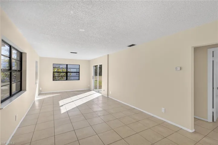 Unfurnished room with light tile patterned flooring and a textured ceiling