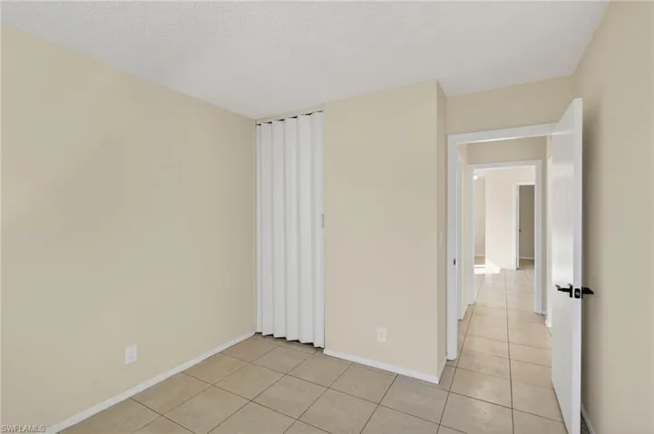 Unfurnished room with a textured ceiling and light tile patterned floors
