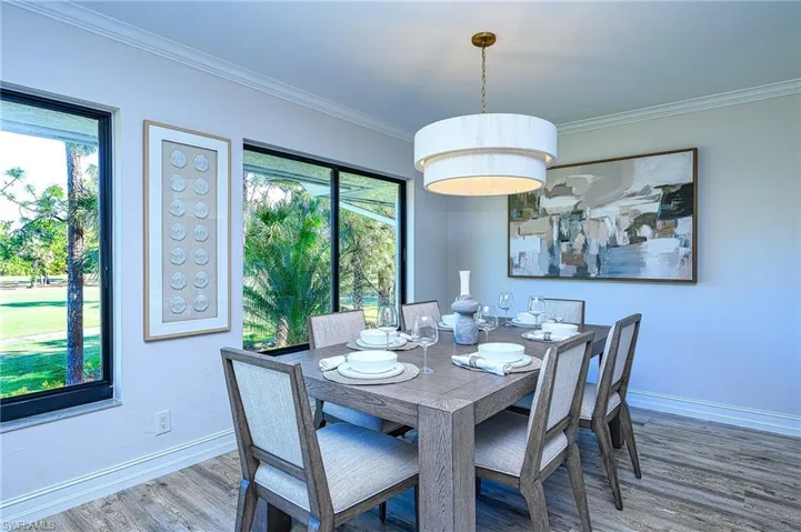 Dining space featuring a wealth of natural light, hardwood / wood-style floors, and ornamental molding