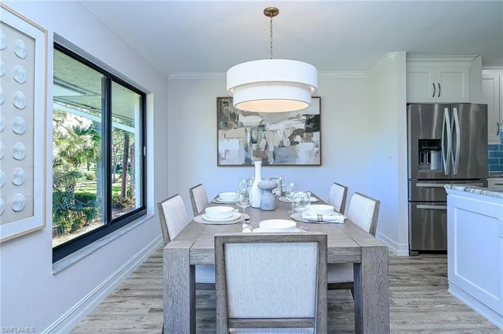 Dining room with light hardwood / wood-style floors and crown molding