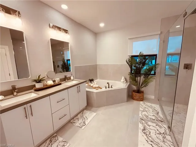 Bathroom featuring tiled bath and vanity