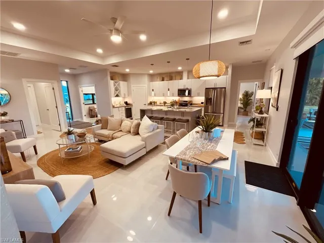 Tiled living room with ceiling fan and a raised ceiling