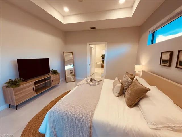 Tiled bedroom with a tray ceiling and ensuite bathroom
