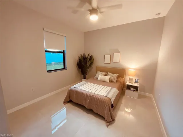 Bedroom with ceiling fan and light tile patterned floors