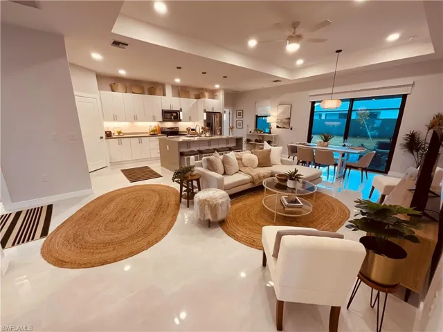 Living room with a tray ceiling and ceiling fan