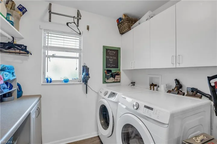 Laundry room with washer and dryer, cabinet space, and baseboards