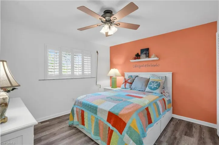 Bedroom featuring ceiling fan, baseboards, and wood finished floors