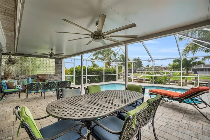 View of patio featuring a ceiling fan, a lanai, an outdoor pool, and outdoor dining area