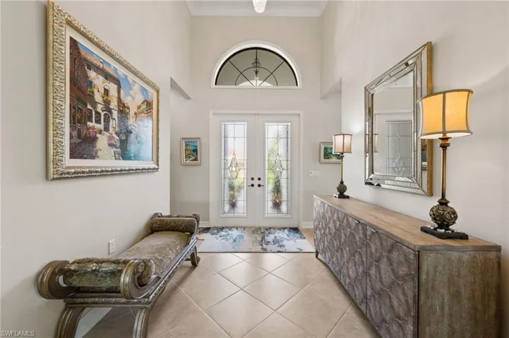 Tiled entryway with crown molding and french doors