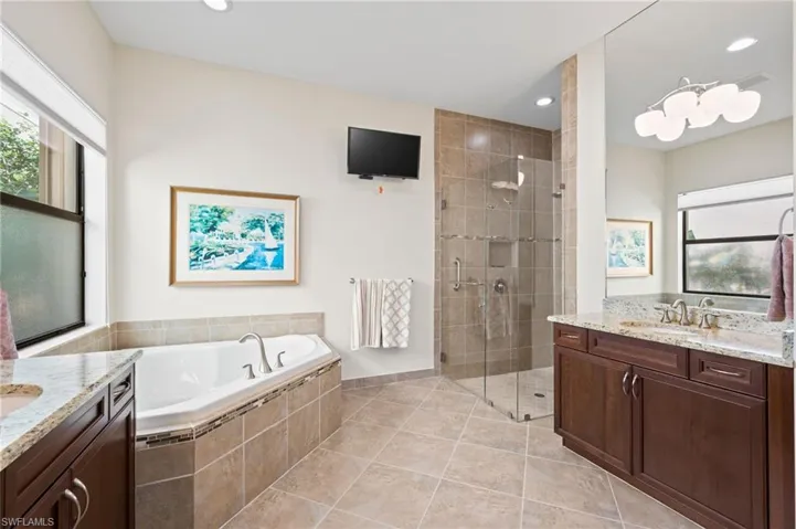 Bathroom featuring shower with separate bathtub, tile patterned floors, and vanity