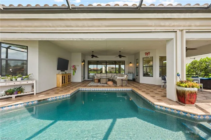 View of pool featuring ceiling fan, an outdoor living space, and a patio area