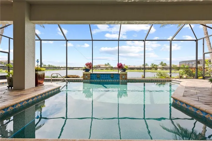 View of pool featuring a patio and glass enclosure