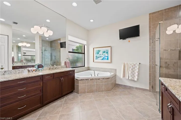Bathroom with tile patterned flooring, vanity, and separate shower and tub