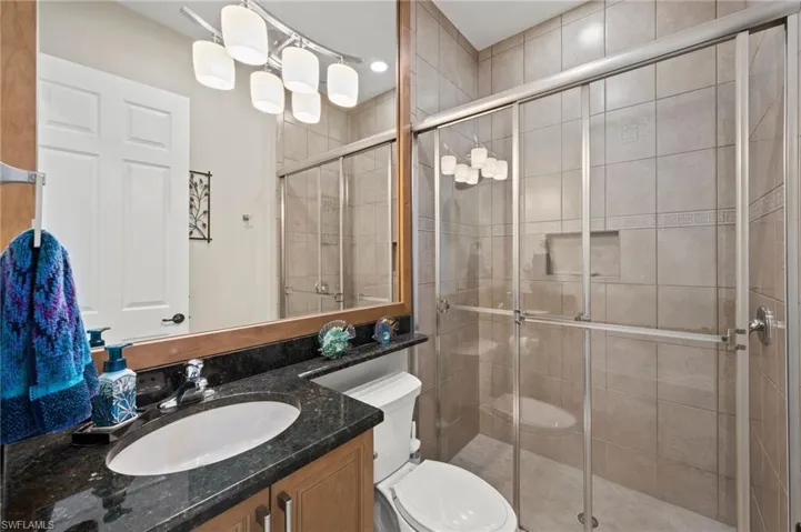 Bathroom with walk in shower, vanity, and toilet