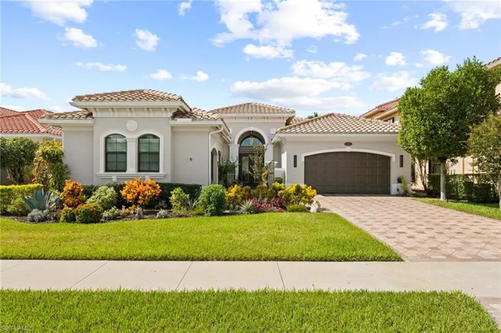 Mediterranean / spanish-style home with a garage and a front lawn