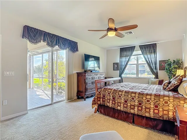Carpeted bedroom with access to outside and ceiling fan
