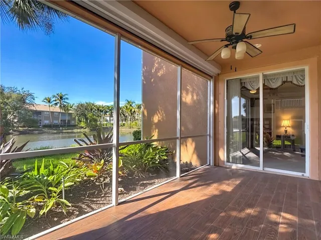 Unfurnished sunroom with ceiling fan and a water view