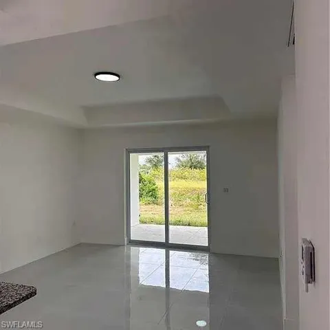 Doorway to outside with light tile patterned floors and a raised ceiling