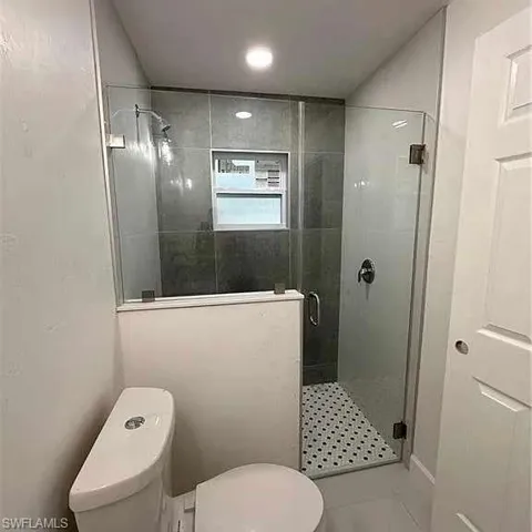 Bathroom with a shower stall and toilet