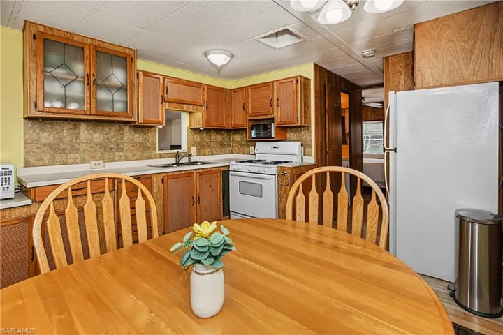 Kitchen with wood cabinetry, integrated appliances, and a tile backsplash