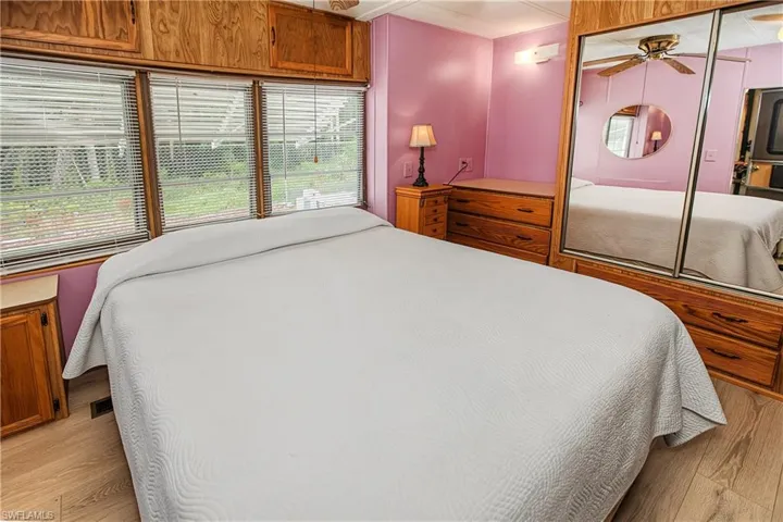 Wood-finish flooring with built-in cabinetry and ceiling fan