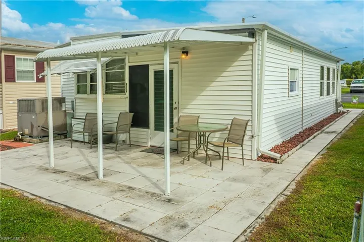 Covered patio featuring a concrete slab and white vinyl siding
