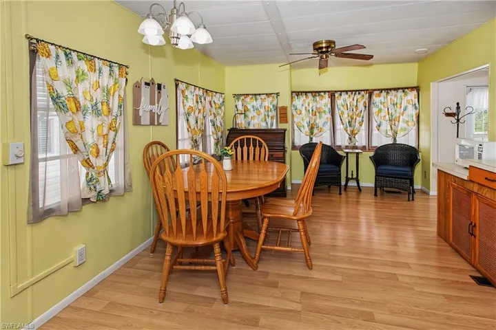 Wood-finish flooring throughout, bright yellow walls, and a multi-light chandelier
