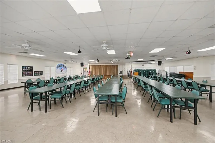 Spacious common area featuring ceiling fans, recessed lighting, and a stage with privacy curtains