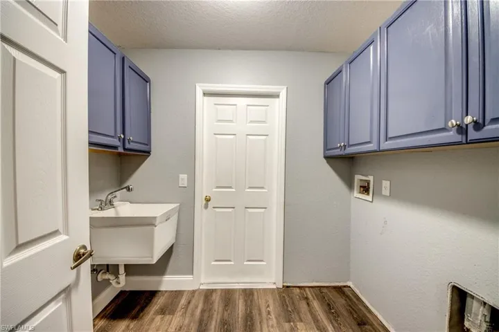 Laundry area featuring a textured ceiling, dark wood finished floors, and washer hookup