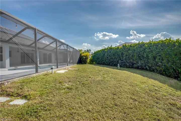 Fenced backyard with glass enclosure, a sunroom, and an outdoor pool