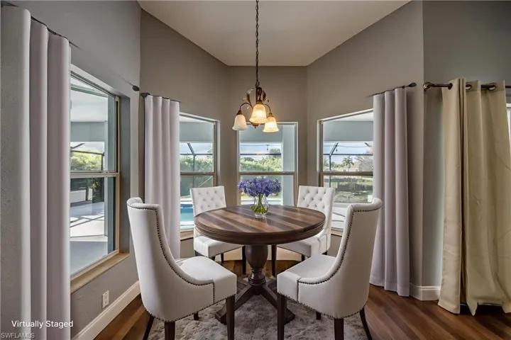 Dining area with hanging lights and dark wood-style flooring
