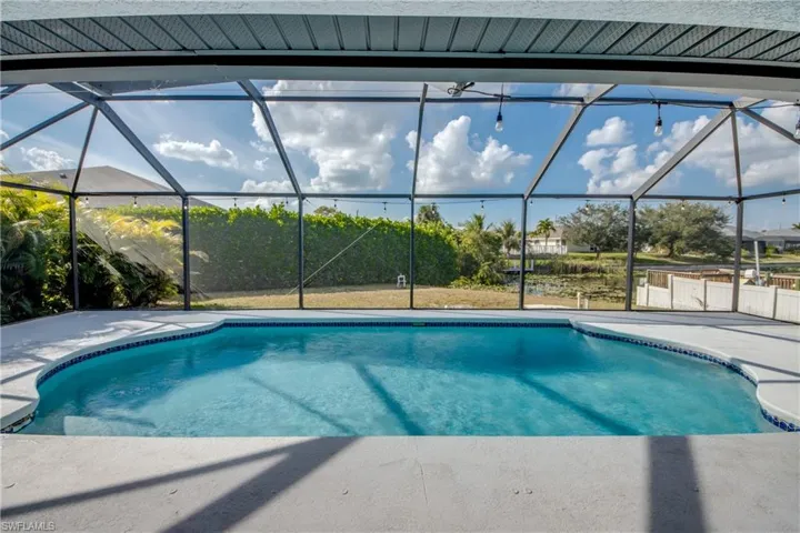 Outdoor pool featuring a sunroom and glass enclosure
