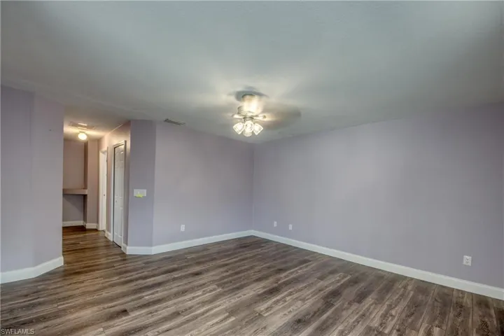 Spare room featuring ceiling fan and dark wood-type flooring