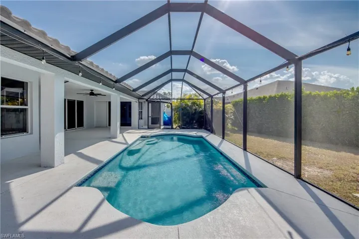 Outdoor pool featuring a sunroom, a lanai, and a patio area