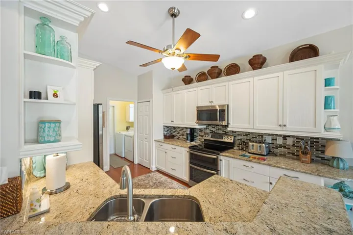 Kitchen with open shelves, white cabinetry, appliances with stainless steel finishes, backsplash, and recessed lighting