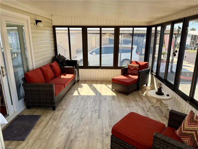 Sunroom / solarium featuring wooden walls and wood finished floors