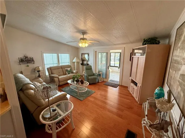 Living area featuring light wood-type flooring, plenty of natural light, and a ceiling fan