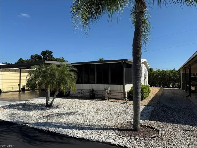 View of front of home with a sunroom and a carport