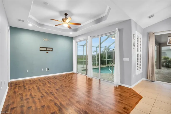 Great room, ceiling fan, and a tray ceiling