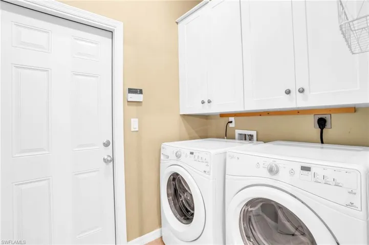 Laundry room with cabinets off of the kitchen and garage