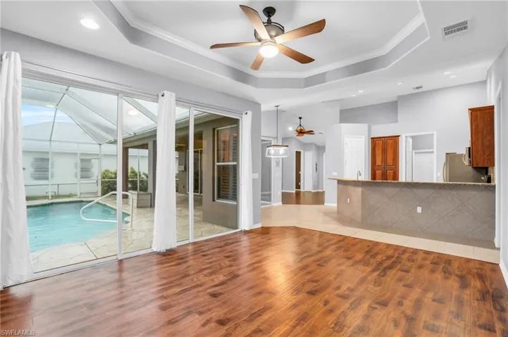 Great room room featuring a tray ceiling and view of pool