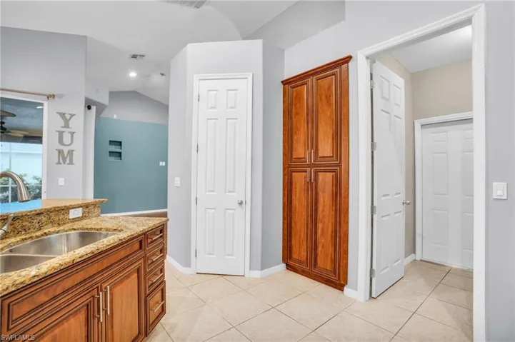 Bathroom featuring sink, tile patterned flooring, vaulted ceiling, and ceiling fan
