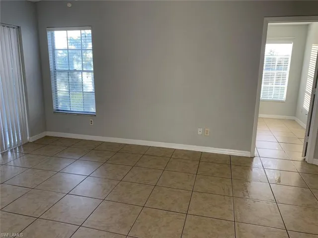 Unfurnished room featuring light tile patterned floors and baseboards