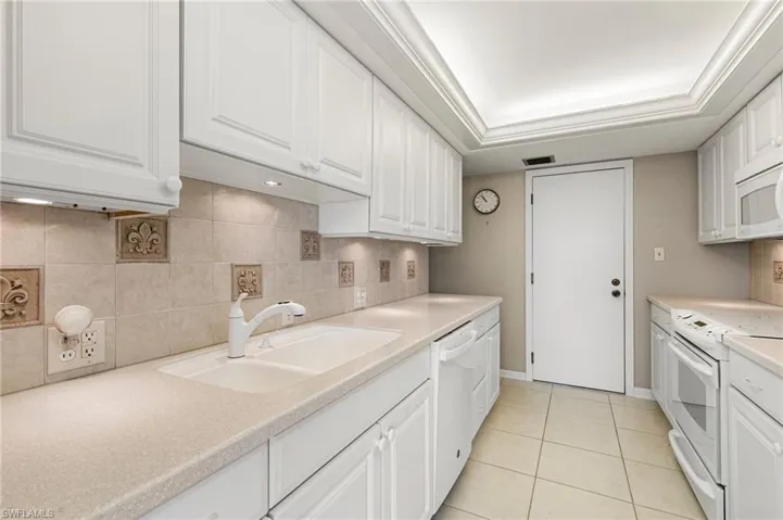 Updated Kitchen w/ tile backsplash, corian counters, and undermount lighting