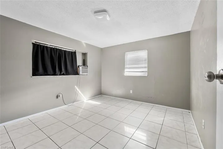 Empty room with cooling unit and a textured ceiling
