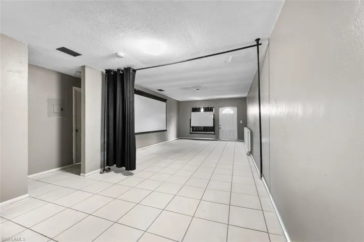 Tiled empty room featuring a textured ceiling
