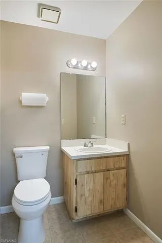 Bathroom featuring vanity, toilet, and tile patterned flooring