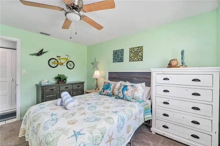 Bedroom with carpet, a ceiling fan, and a textured ceiling