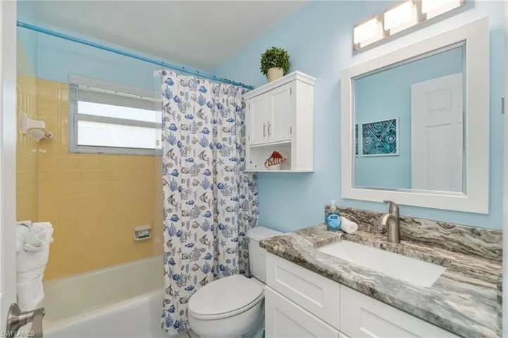 Full bath with shower / bath combo with shower curtain and vanity